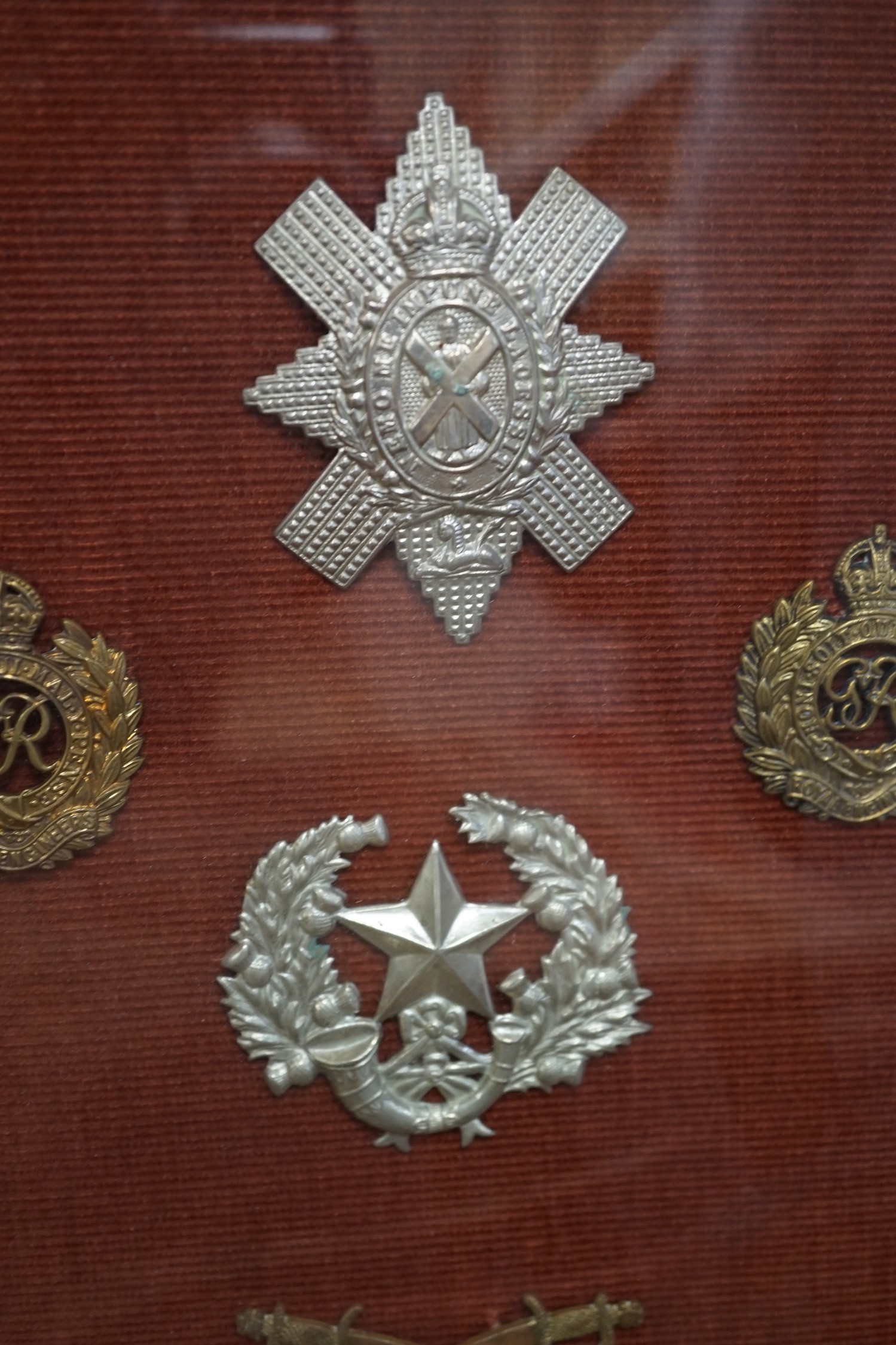 A framed collection of military cap Badges